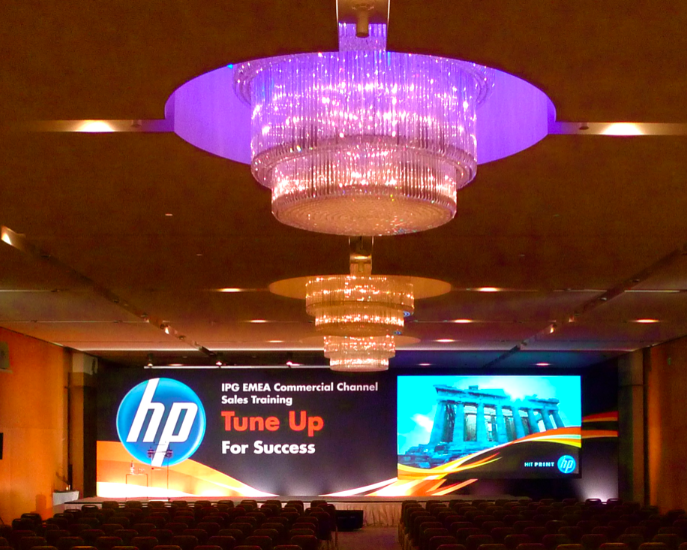 Main plenary stage for HP EMEA Commercial Channel Sales Training event with large branded presentation screen and audience seating, produced by Bano Event Technology Main plenary stage for HP EMEA Commercial Channel Sales Training event with large branded presentation screen and audience seating, produced by Bano Event Technology
